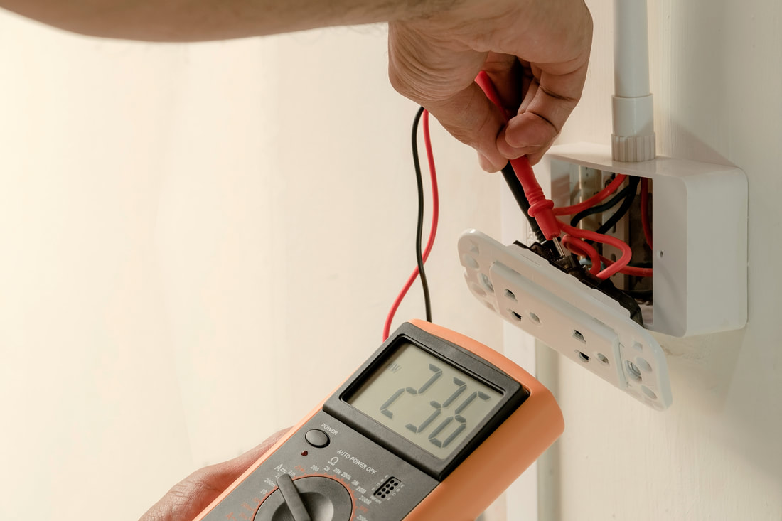 An electrician reads the voltage on a wall outletPicture